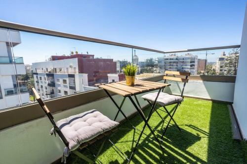 a balcony with a wooden table and two chairs at Modern Charm at Le Joyau du Parc in Mohammedia