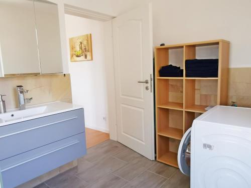 a bathroom with a sink and a washing machine at Musashi Apartment 3 in Weimar