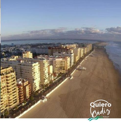 a view of a beach with buildings and the ocean at Quiero Cádiz in Cádiz