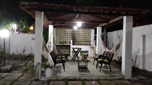 a patio at night with chairs and a table at Casarão na Praia de Camboinha a 250 metros do mar in Cabedelo