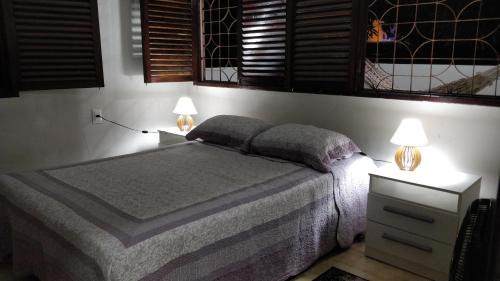 um quarto com uma cama e duas mesas de cabeceira com candeeiros em Casarão na Praia de Camboinha a 250 metros do mar em Cabedelo