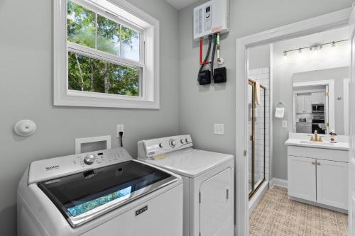a white laundry room with a washer and dryer at Ferry House in Supply