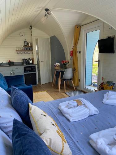 a living room with two beds and a kitchen at Cwt y Gwenyn Glamping Pod in Conwy