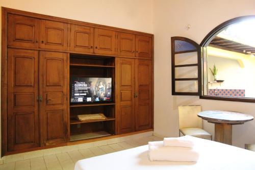 a room with a large wooden cabinet with a television at Hospedaria Bem Te Vi Arraial d'Ajuda in Arraial d'Ajuda