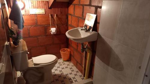 a small bathroom with a toilet and a sink at La Cabaña posada turística in Buenaventura