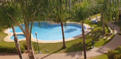 uma vista superior de uma piscina entre palmeiras em Le 21 Armada Tower em Bouznika