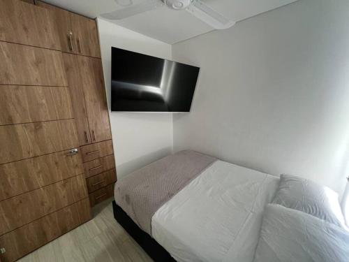 a bedroom with a bed and a flat screen tv at Hermosa casa muy equipada para descansar in Ricaurte