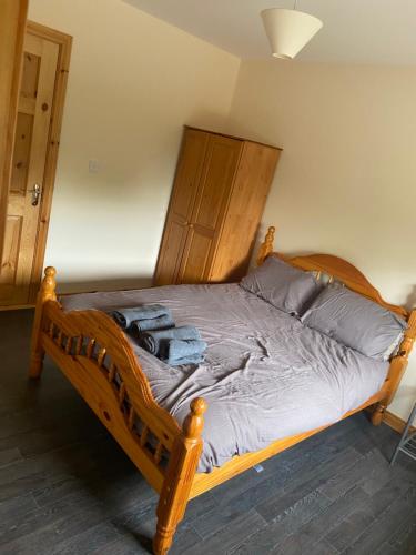 1 dormitorio con cama de madera y cabecero de madera en Higgins House en Ballyhaunis