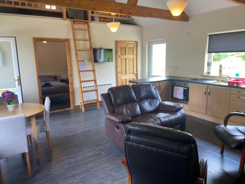 a living room with a leather couch and a table at Higgins House in Ballyhaunis