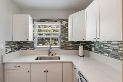 a kitchen with white cabinets and a sink at Palmetto Home with Manatee River Access! in Palmetto
