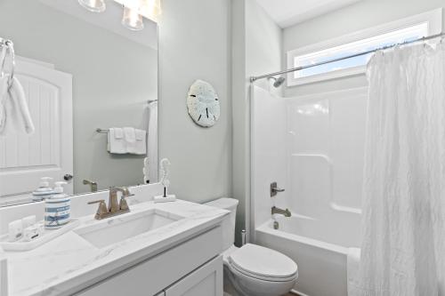 a white bathroom with a sink and a toilet at Ferry House - Upper Unit in Supply