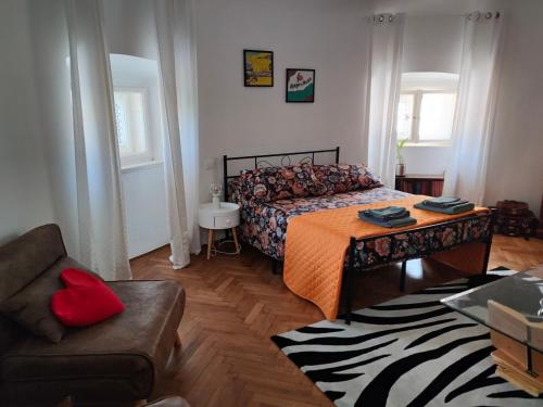 um quarto com uma cama, uma cadeira e um sofá em Volta 8 rooms em Trieste