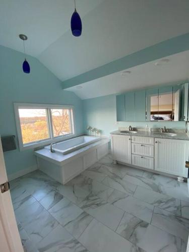 a large white bathroom with a tub and a sink at Salmon River View in Pulaski