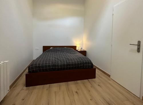 um quarto com uma cama e piso em madeira em T4 Cosy dans ferme rénovée à 2 minutes de Genève em Collonges-sous-Salève