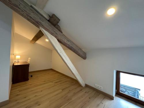 an attic room with wooden beams on the ceiling at T4 Cosy dans ferme rénovée à 2 minutes de Genève in Collonges-sous-Salève