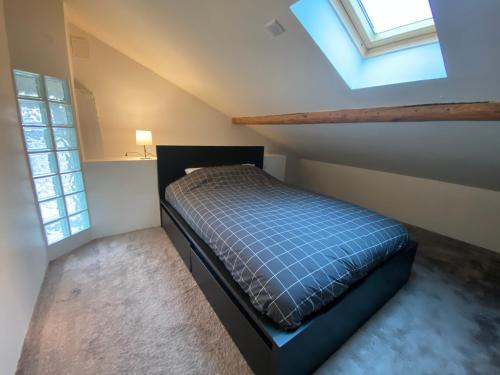 a small bedroom with a bed in a attic at T4 Cosy dans ferme rénovée à 2 minutes de Genève in Collonges-sous-Salève