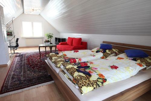ein Schlafzimmer mit einem großen Bett und einem roten Stuhl in der Unterkunft Residenz Labee in Weil am Rhein