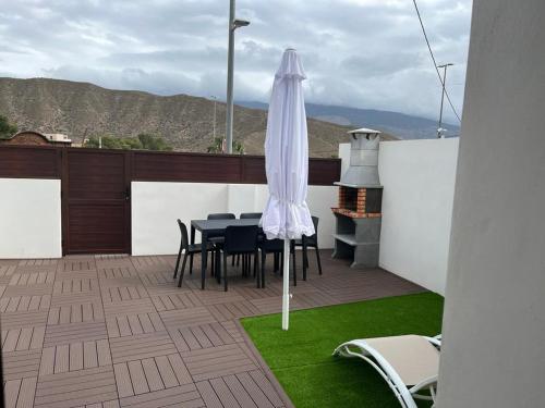 um pátio com uma mesa, um guarda-chuva e um grelhador em Casa La Zurita em Tabernas