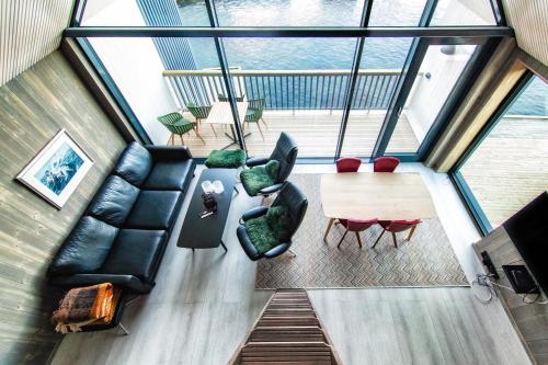 vistas panorámicas a una sala de estar con mesa y sillas en Rorbuleilighet Lysøysundet 1G, en Henningsvaer