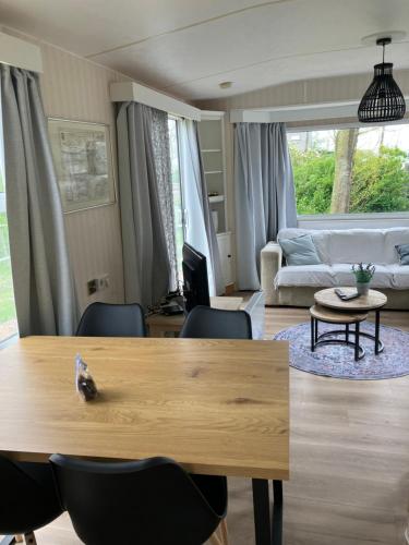 a living room with a table and a couch at Chalet Stal Veersedam in Kamperland