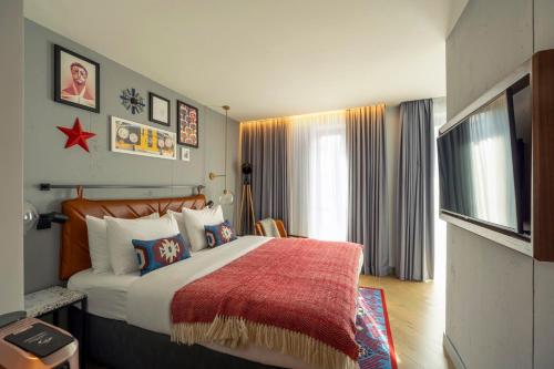 a bedroom with a large bed with a red blanket at Hotel Indigo Belgrade by IHG in Belgrade