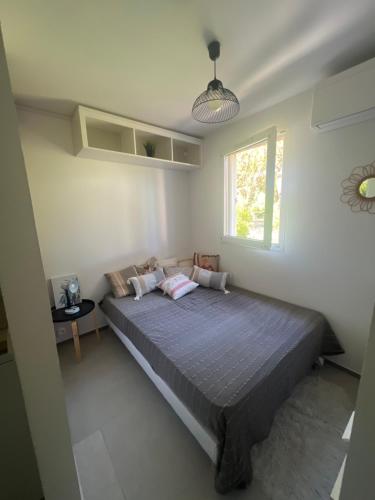 um quarto com uma cama e uma janela em Appartement pied dans l’eau em La Seyne-sur-Mer