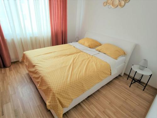 a bedroom with a bed with a yellow blanket on it at Apartment Elena inklusive Garagenplatz in Vienna