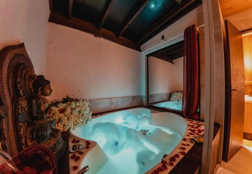 a bath tub in the corner of a room at Pousada Jardim do Buda com Café e Piscina in Urubici