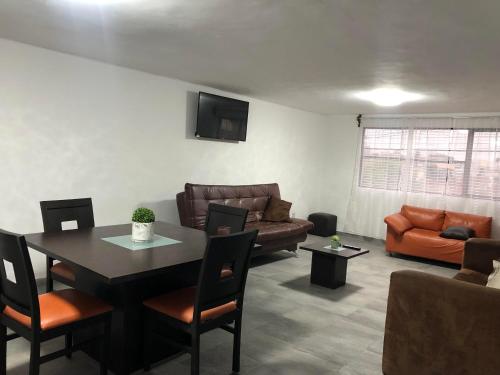 a living room with a table and a couch at Suites Incoreli, Departamento 4 in Pachuca de Soto