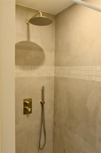 y baño con ducha con cabezal de ducha. en Downtown 1BDR Apartment 4 en Amberes