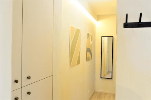 pasillo con armarios blancos y espejo en Downtown 1BDR Apartment 4 en Amberes