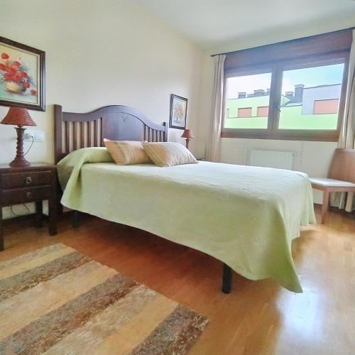 um quarto com uma cama grande e uma janela em Apartamento Seronda em Villaviciosa
