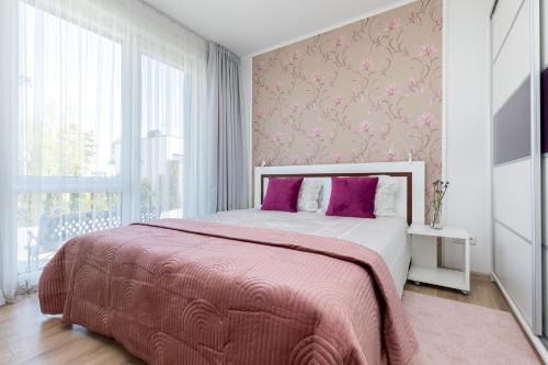 帕蘭加的住宿－SEA GARDEN atostogų namai su šildomu baseinu, Kunigiškiai，一间卧室配有一张带粉色毯子的大床