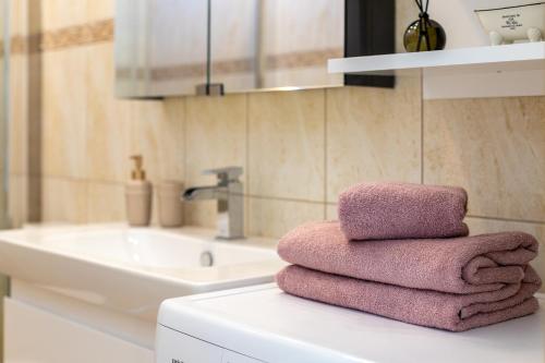 uma pilha de toalhas sentadas num balcão na casa de banho em SEA GARDEN atostogų namai su šildomu baseinu, Kunigiškiai em Palanga