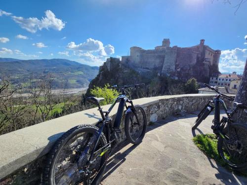 two bikes parked on a path with a castle in the background at B&B di Giuseppe Pighi in Bardi