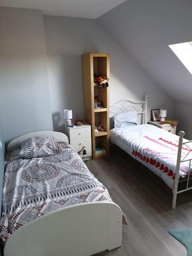 une chambre avec un lit et une étagère dans l'établissement Maison spacieuse au calme à 5 min de la ville, à Aigné