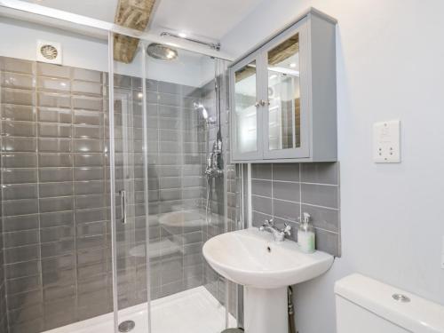 La salle de bains blanche est pourvue d'un lavabo et d'une douche. dans l'établissement Viaduct House, à Lydbrook
