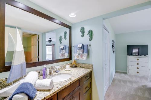 a bathroom with a sink and a large mirror at Little River Condo with Balcony Pool and Hot Tub! in Little River