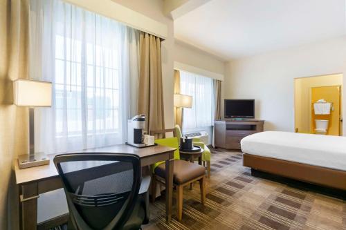 a hotel room with a bed and a desk and a bed and a room at Best Western Plus The Inn at Horse Heaven in Prosser