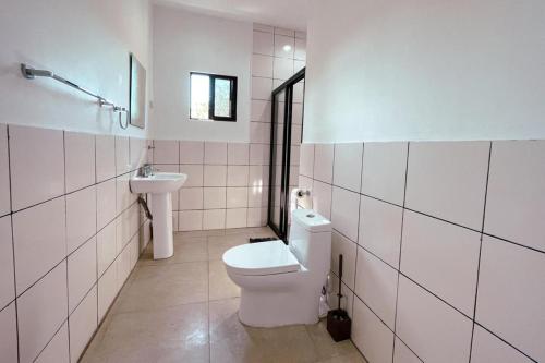 uma casa de banho branca com um WC e um lavatório em Beth's Villa em Moalboal