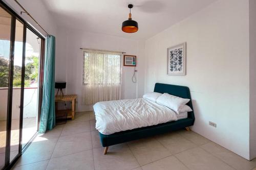 a bedroom with a bed and a large window at Beth's Villa in Moalboal