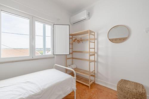 Un dormitorio con una cama y un espejo y una ventana. en Bento Caraça Terrace, en Alcácer do Sal