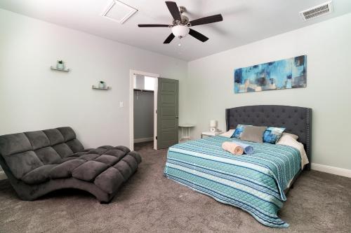 サンアントニオにあるCasa Dolce Vita by the Alamodomeのベッドルーム1室(ベッド1台、ソファ、天井ファン付)