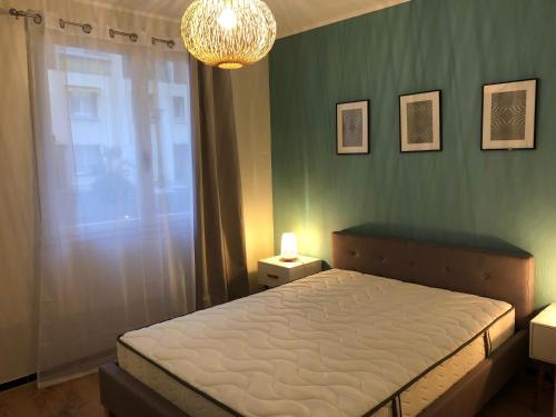 une chambre avec un lit et un lustre dans l'établissement 2P cosy plein centre Antibes, à Antibes