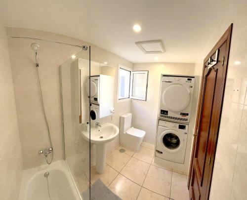 y baño con lavamanos y lavadora. en Fit-House Fuerteventura Wifi & Gym, en Puerto del Rosario