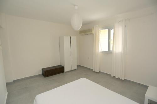 a white room with a bed and a refrigerator at River & Sea Villa in Cesme