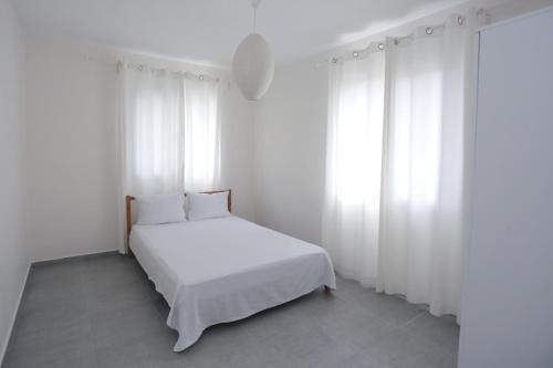 a white bedroom with a white bed and white curtains at River & Sea Villa in Cesme