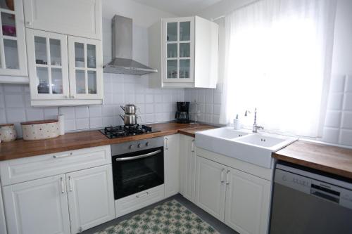 a white kitchen with white cabinets and a sink at River & Sea Villa in Cesme