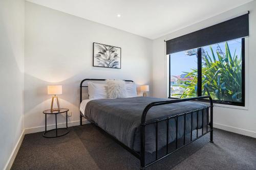 a bedroom with a bed and a large window at Bliss at South Beach in Port Fairy
