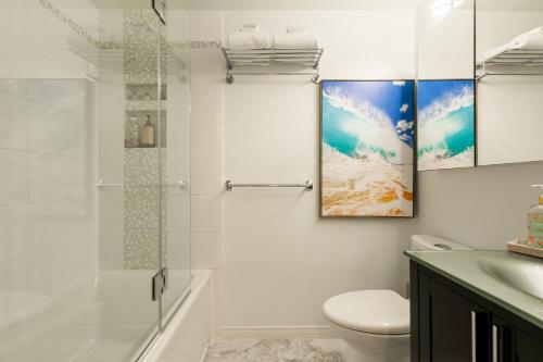 a white bathroom with a shower and a toilet at Le Beachside by Gestion ELITE in Mont-Tremblant